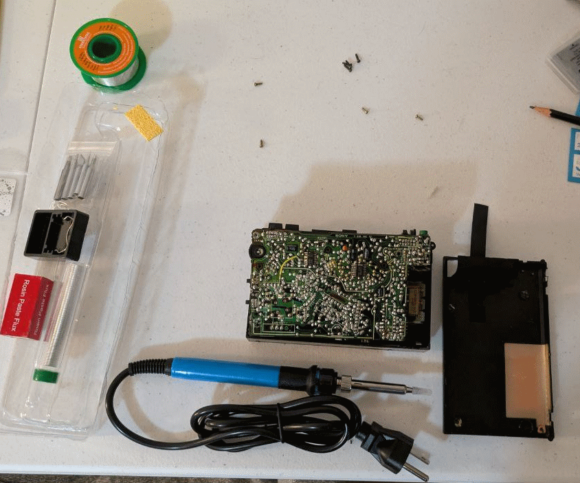 The Walkman laid out on a table with a soldering iron